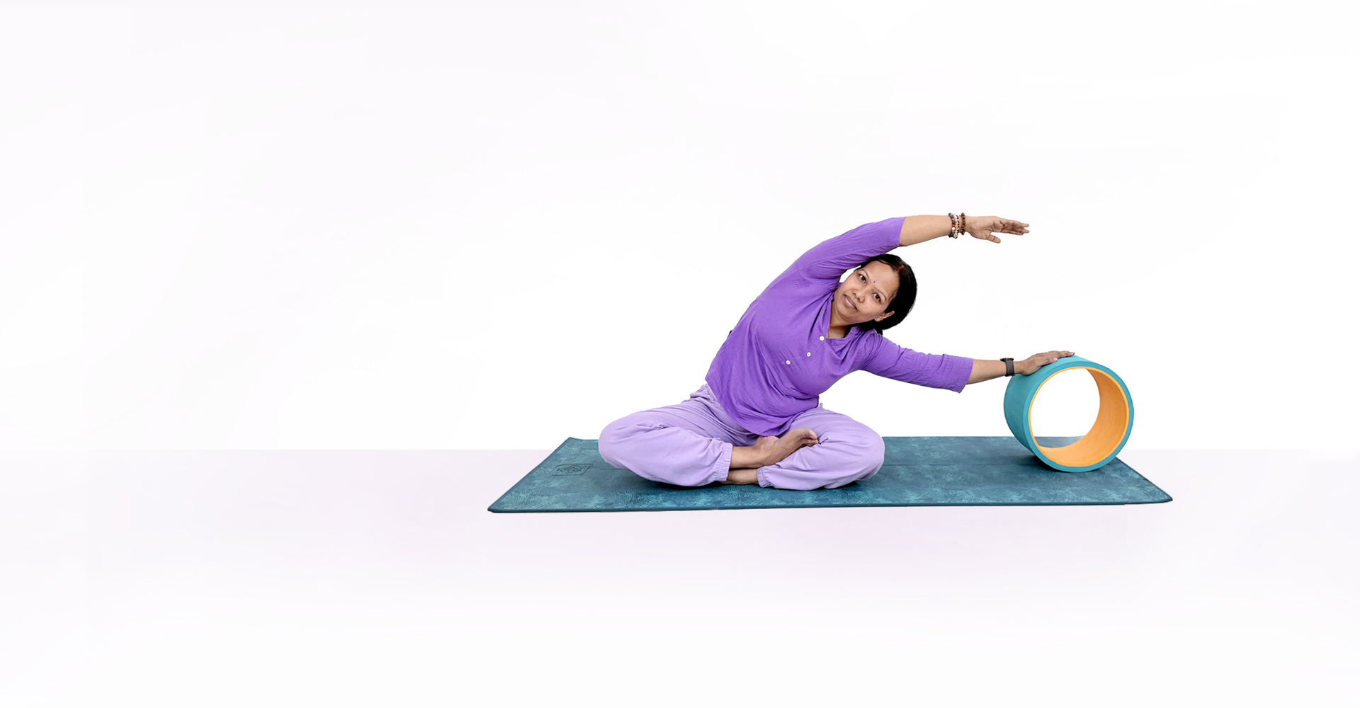 Samatva Yoga practice session - Seated side stretch with yoga wheel prop